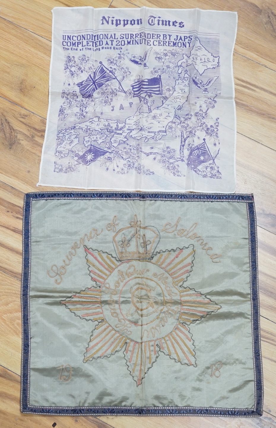 A WWII silk printed handkerchief; ‘Nippon Times’ commemorating the surrender of the Japanese, together with a WWI Army Service Corps emblem dated 1918, 44 x 45cm